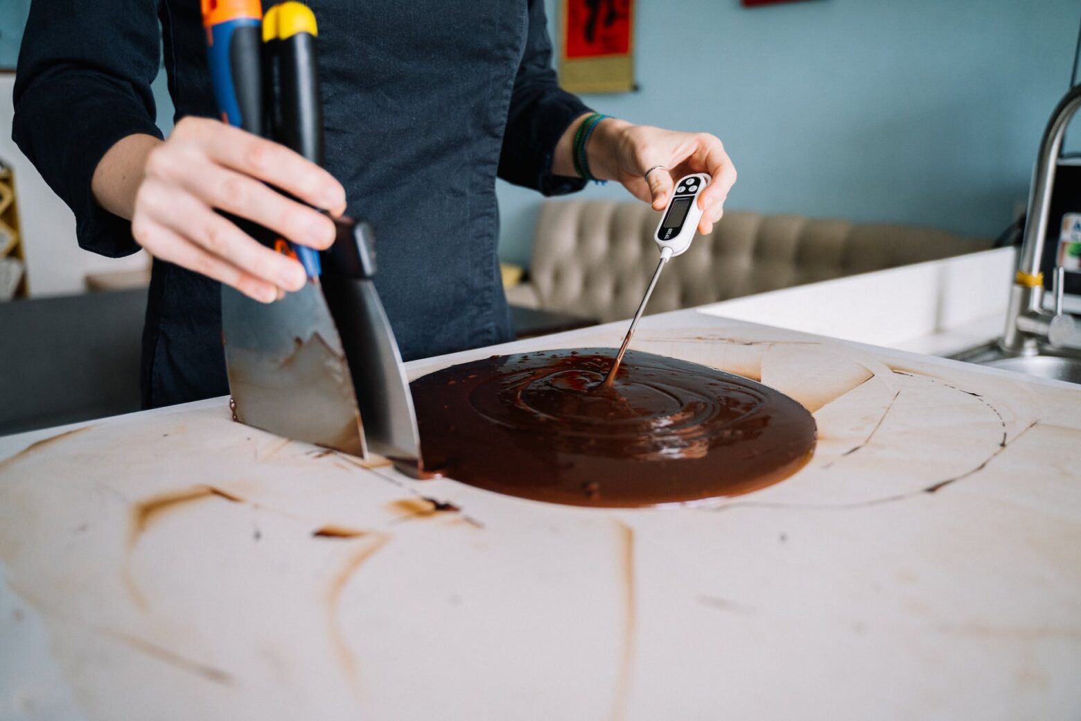 person checking the temperature of a chocolate icing